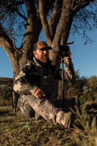 a man sitting on the ground with binoculars
