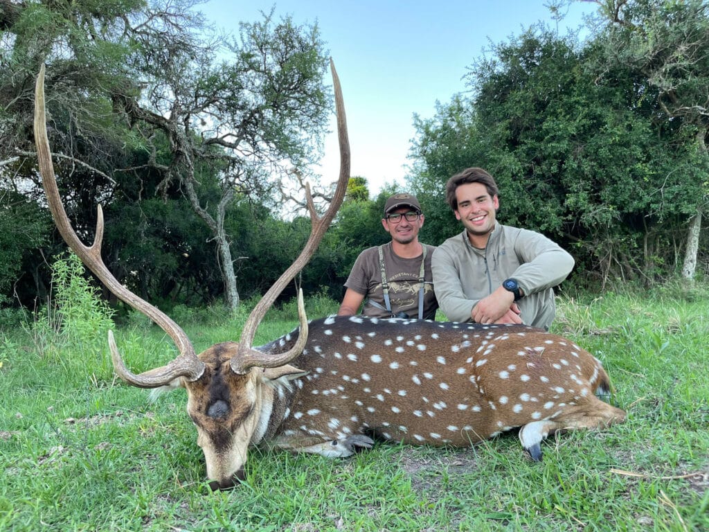 two men posing with a deer